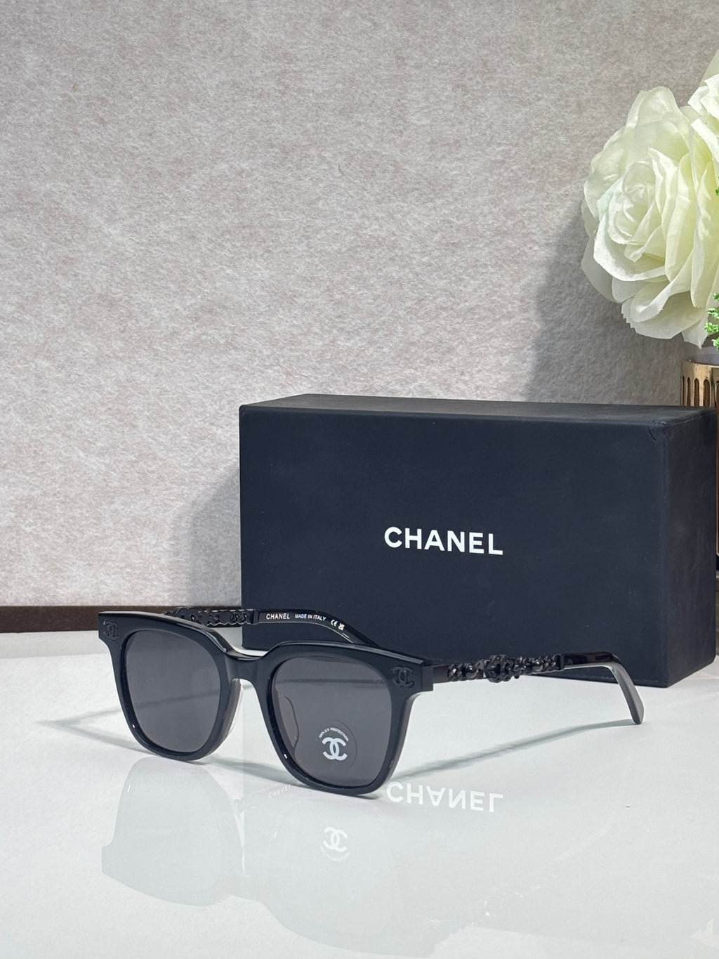 Sunglasses with black frames and dark lenses, with ornate temple detailing