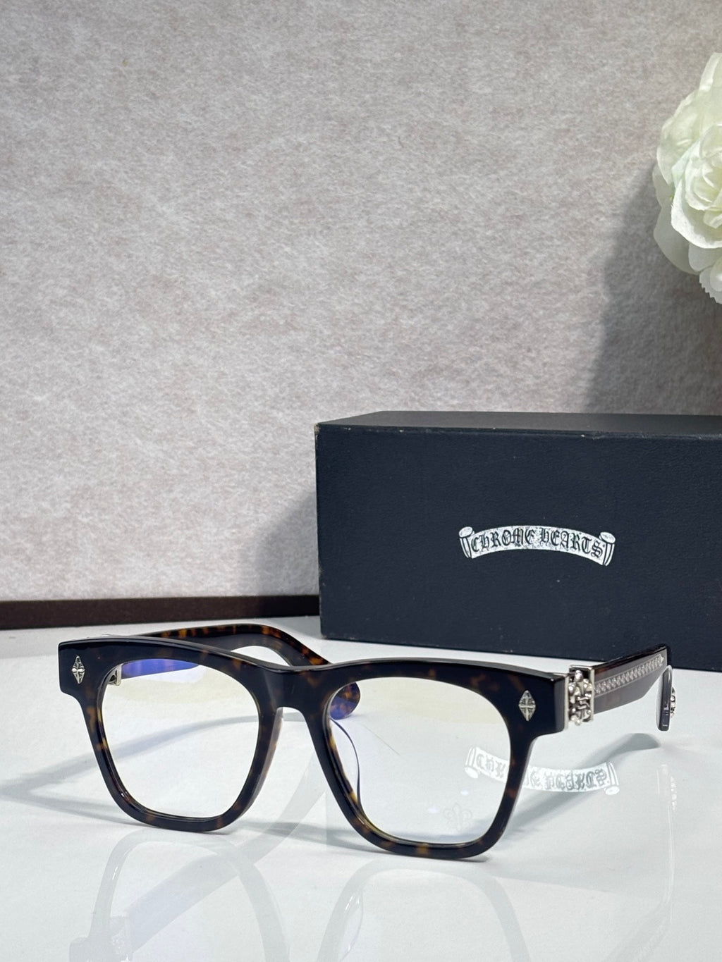 Chrome glasses with dark frames, gold-tone hinges, and blue-tinted lens view