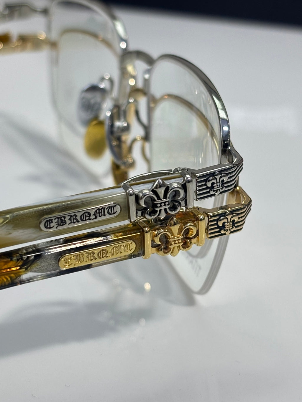 Close-up of gold-tone eyeglass temples with ornate engravings and clear lenses
