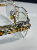 Close-up of gold-tone eyeglass temples with ornate engravings and clear lenses