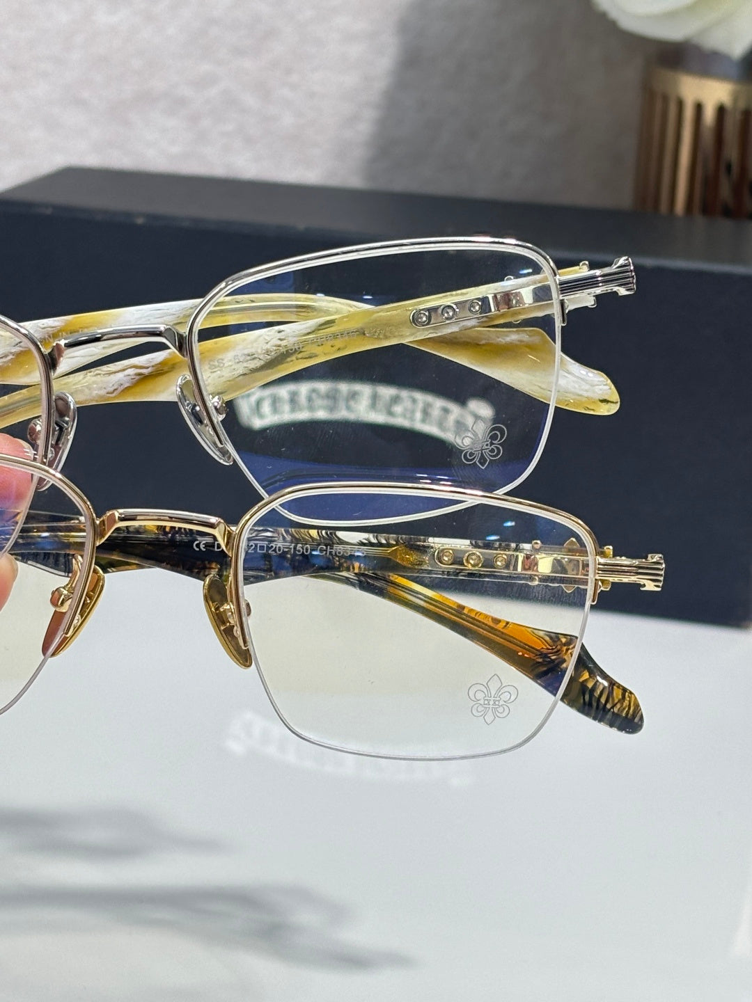 Gold-tone eyeglass frames with clear lenses, side view of ornate temple hardware