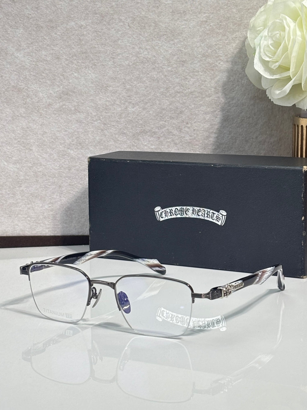 Silver and black eyeglasses with clear lenses, curved arms, and detailed metalwork