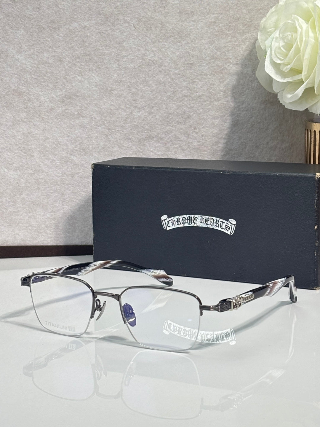 Silver and black eyeglasses with clear lenses, curved arms, and detailed metalwork