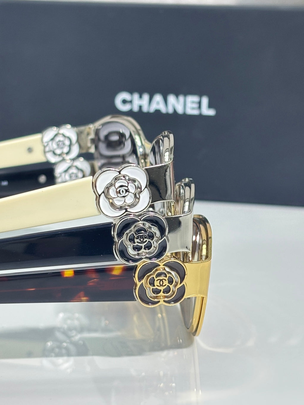 Chanel sunglasses close-up, gold floral and animal charms on dark temples