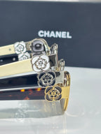 Chanel sunglasses close-up, gold floral and animal charms on dark temples