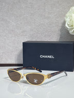 Chanel sunglasses, gold frames with brown lenses, dark temple tips
