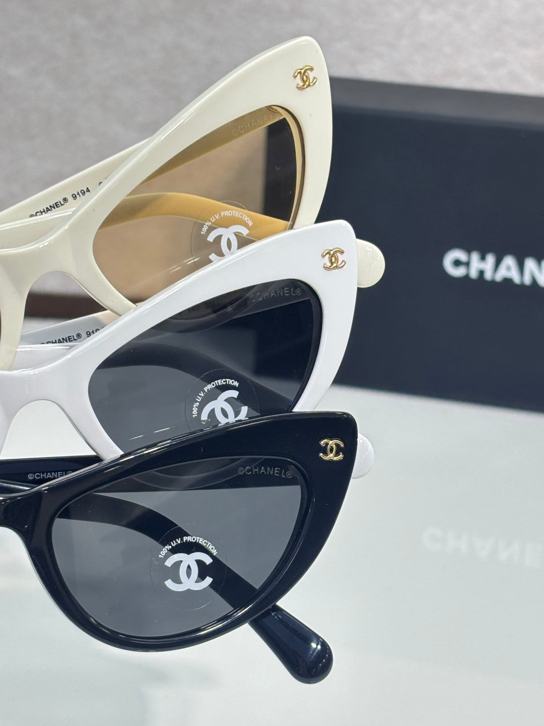 Chanel cat-eye sunglasses set with white frames and dark lenses