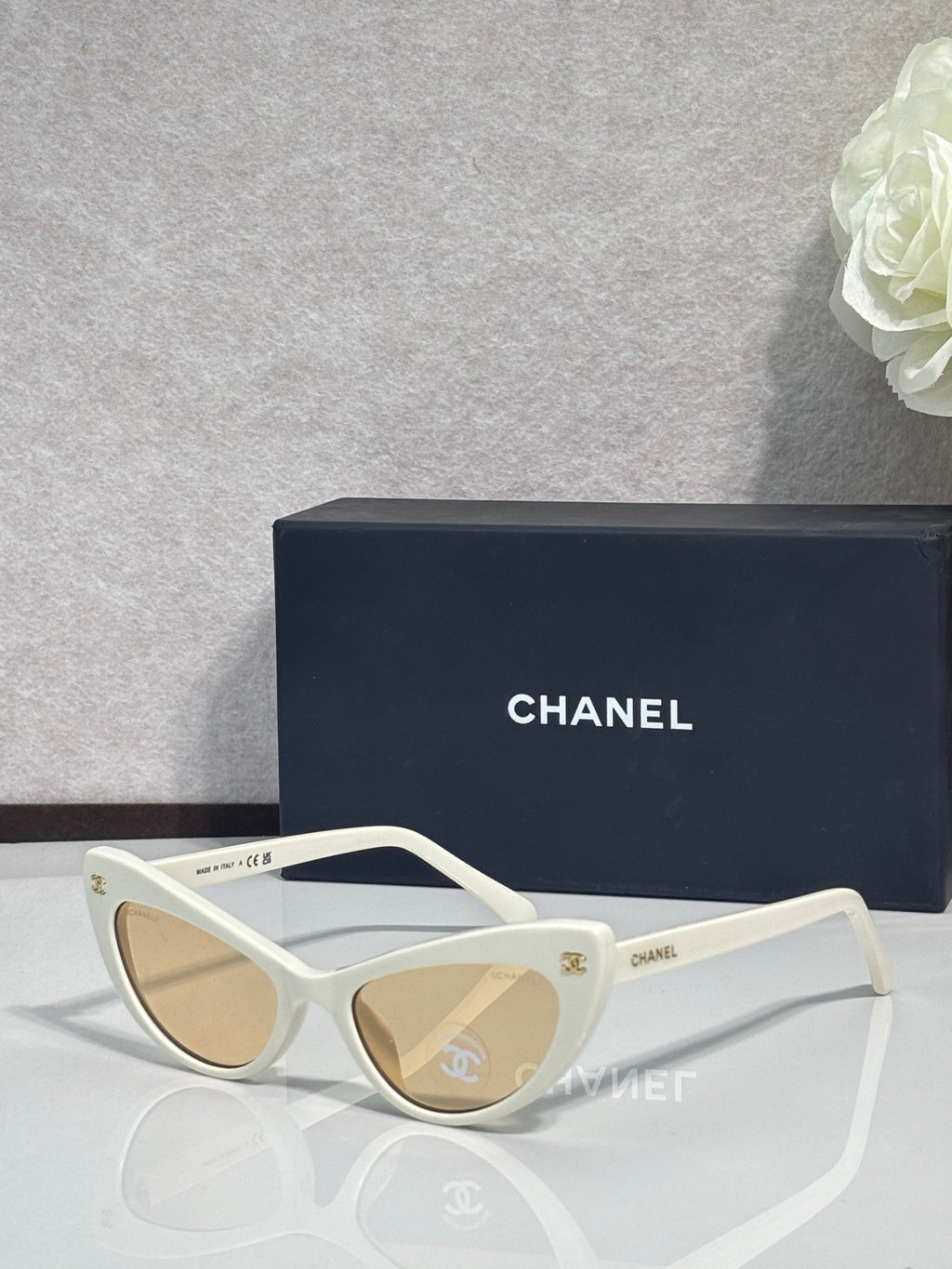 Chanel cat-eye sunglasses with white frames and light beige tinted lenses
