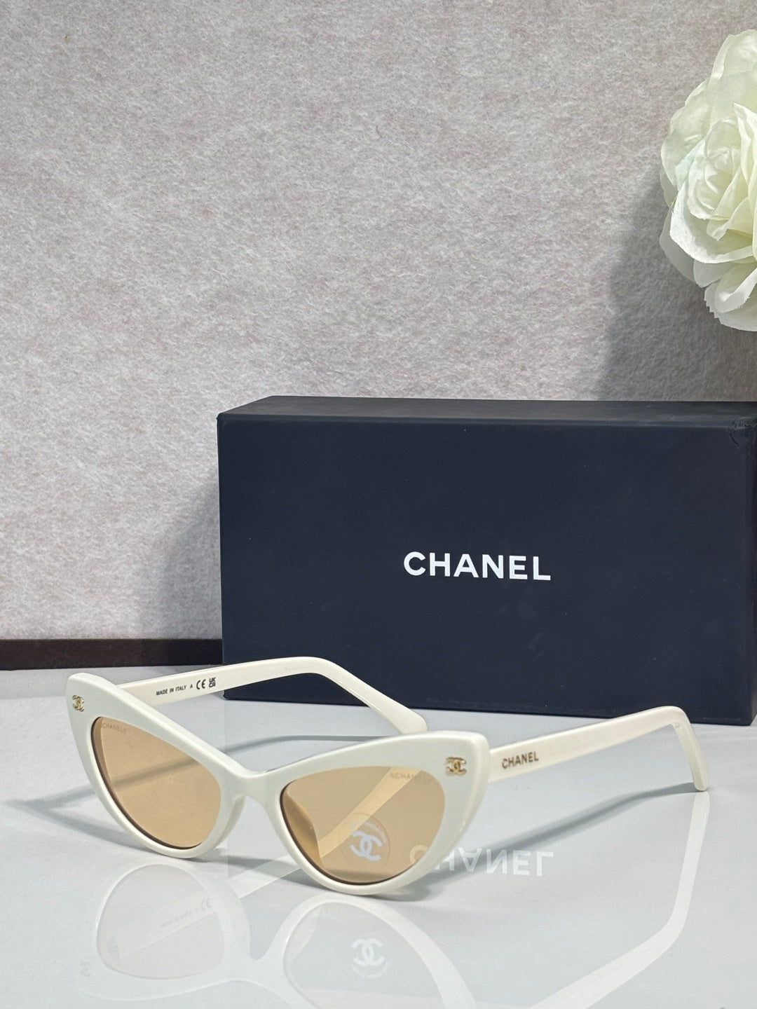 Chanel cat-eye sunglasses with white frames and light beige tinted lenses