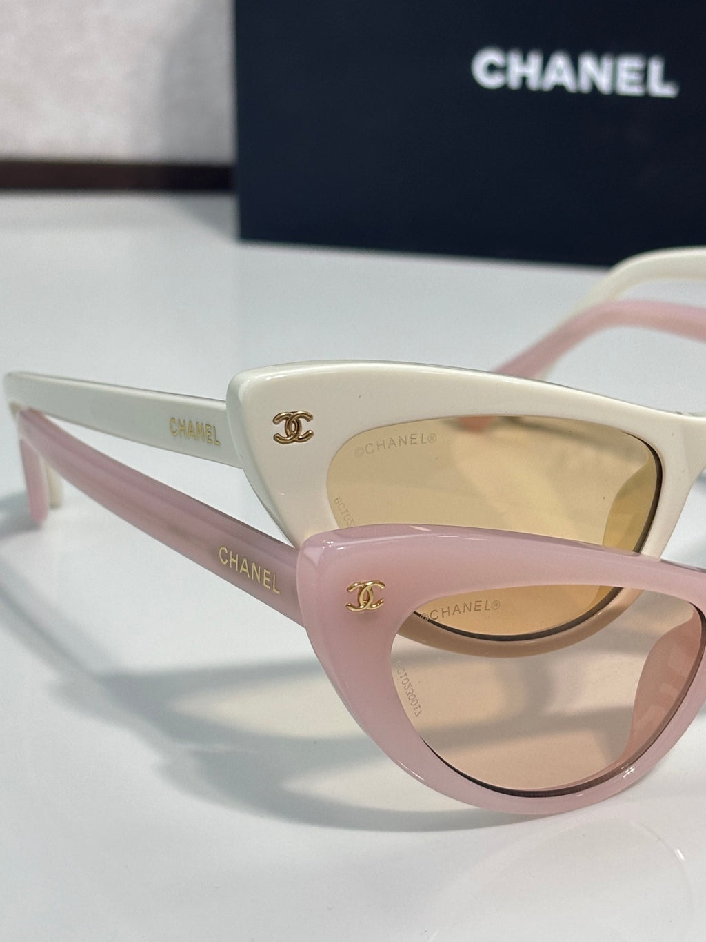 Chanel cat-eye sunglasses with pink and cream frames and beige gradient lenses