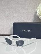 Chanel cat-eye sunglasses with white frames and dark gradient lenses
