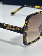 Chanel sunglasses close-up with dark tortoiseshell temples and dark lens