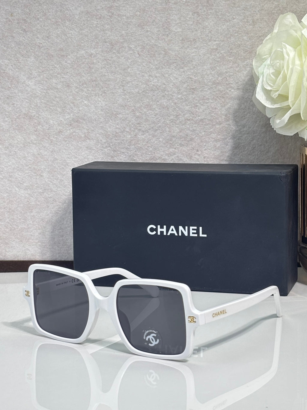 Chanel sunglasses with white frames and dark gray tinted lenses