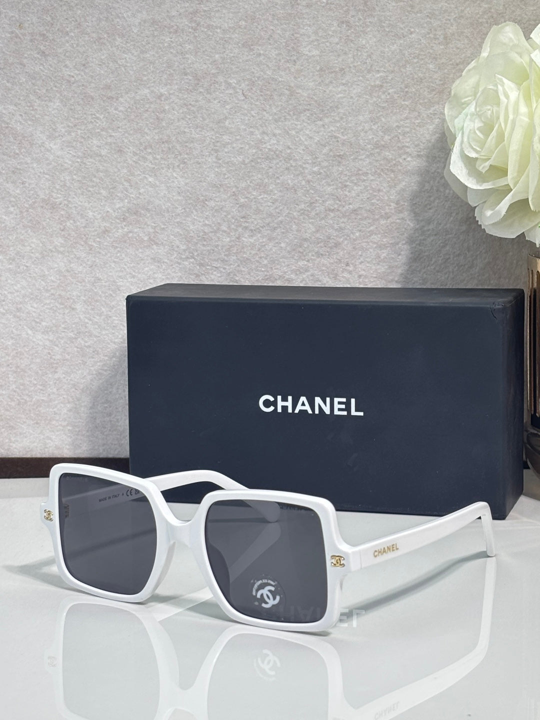 Chanel sunglasses with white frames and dark gray tinted lenses