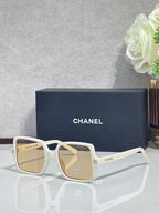 Chanel sunglasses with white frames and light beige tinted lenses
