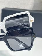 Chanel sunglasses with white frames and dark gray mirrored lenses