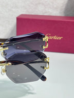 Cartier sunglasses close-up with dark blue tinted lenses and gold-tone metal frame