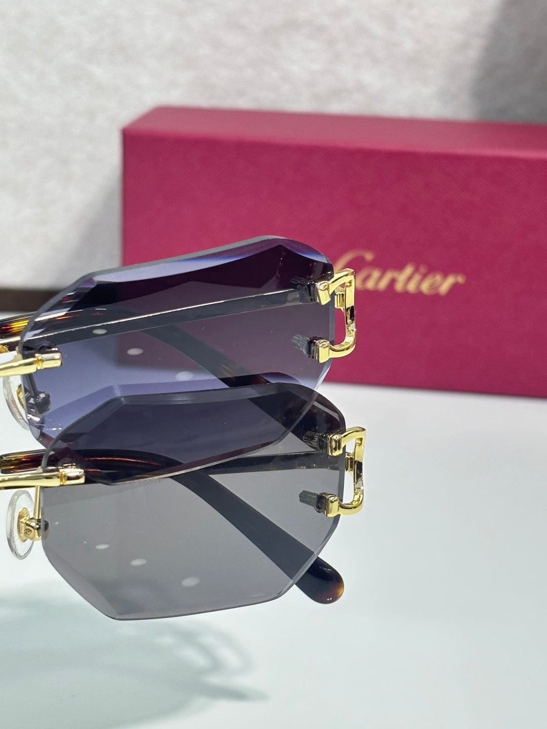 Cartier sunglasses close-up with dark blue tinted lenses and gold-tone metal frame