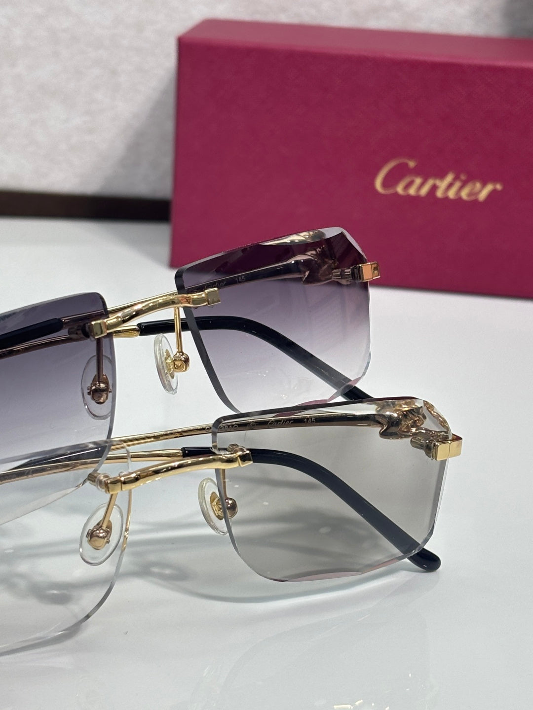 Gold-tone rectangular eyeglasses with purple tinted lenses and black temple accents