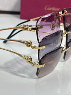 Cartier eyeglasses close-up: ornate gold temple detailing with purple tinted lenses