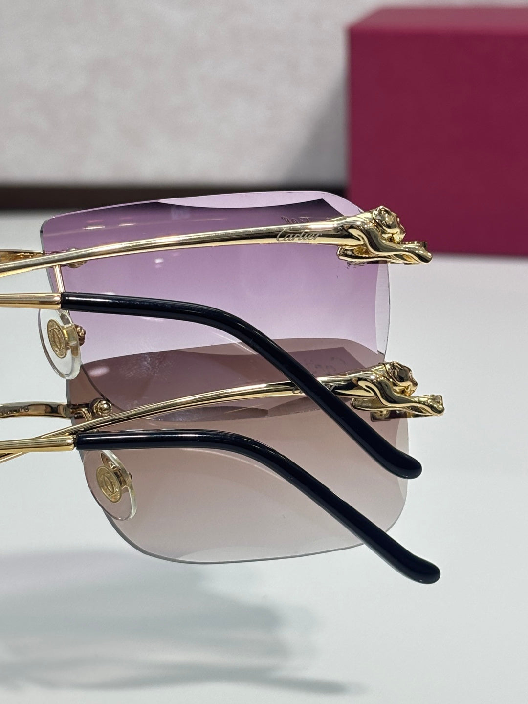 Gold-tone eyeglasses with purple-tinted lenses and curved black temple arms