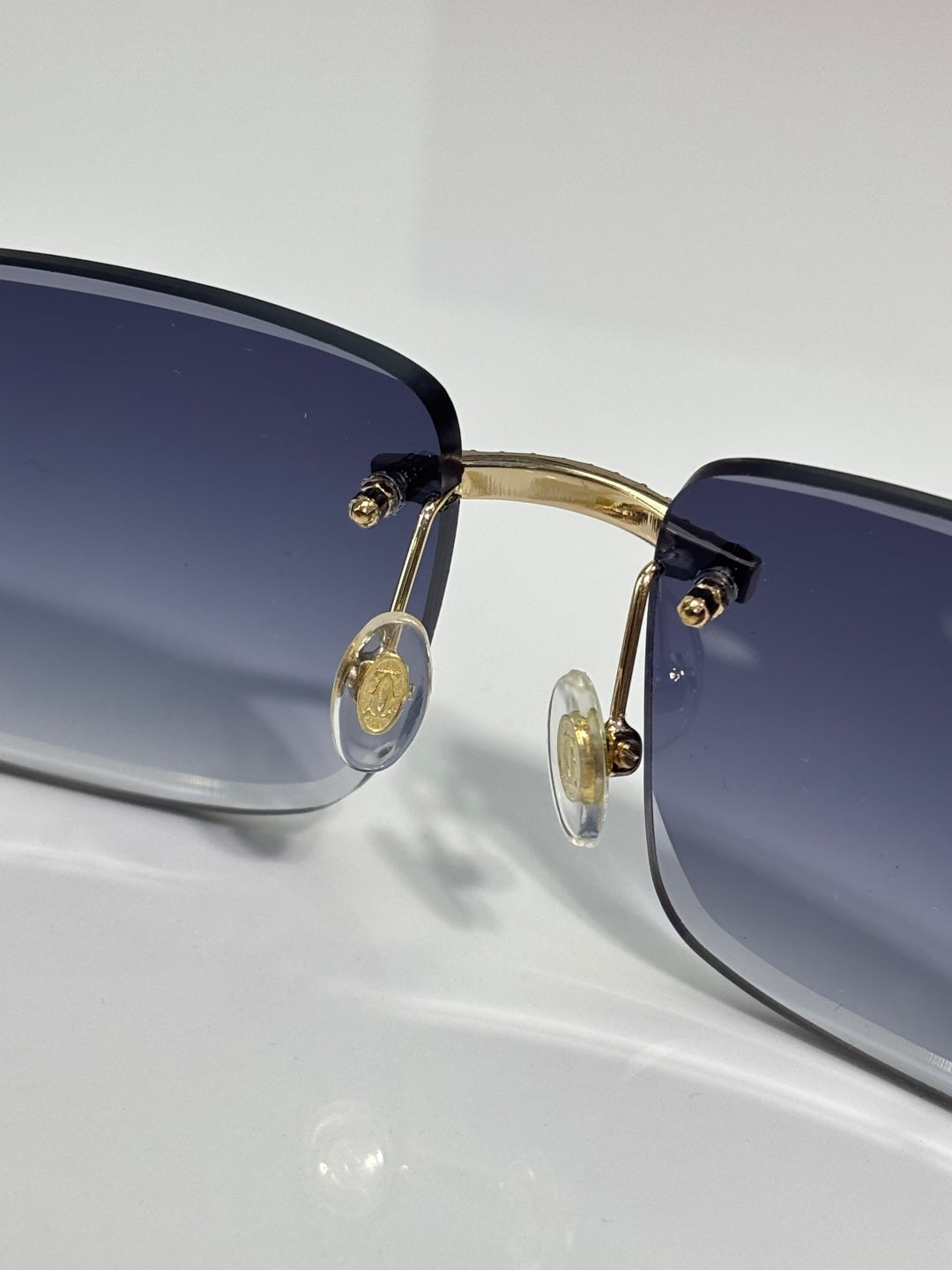 Gold-tone metal eyeglasses with blue-tinted lenses and round temple details