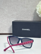Navy blue square sunglasses with magenta temple accent, dark gradient lenses, logo