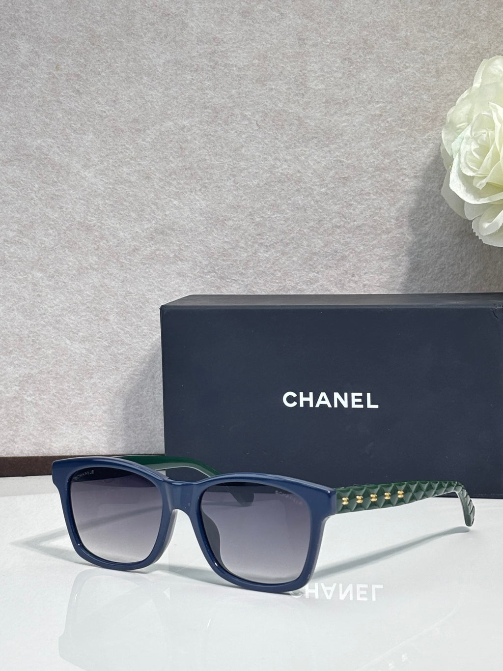 Blue square sunglasses with green patterned temple, dark gradient lenses, logo on frame