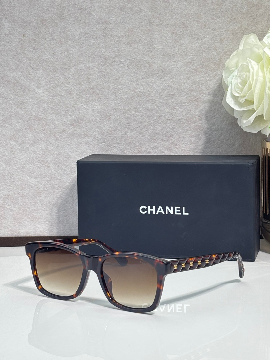 Tortoiseshell square sunglasses with dark gradient lenses, gold studded temple details