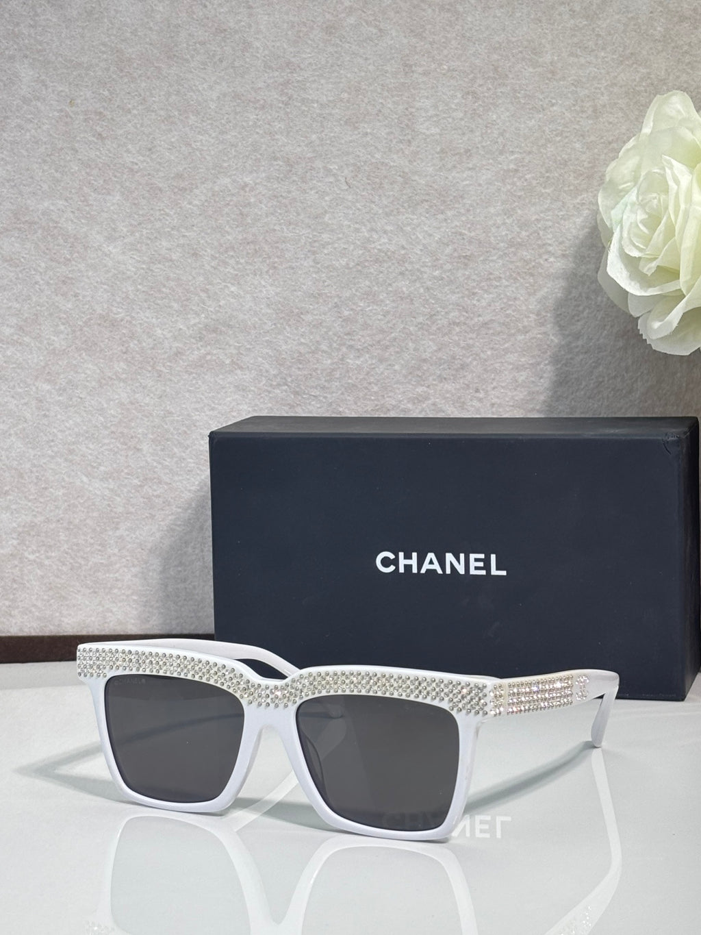 Chanel dark-lens sunglasses with white frame and silver rhinestone side band