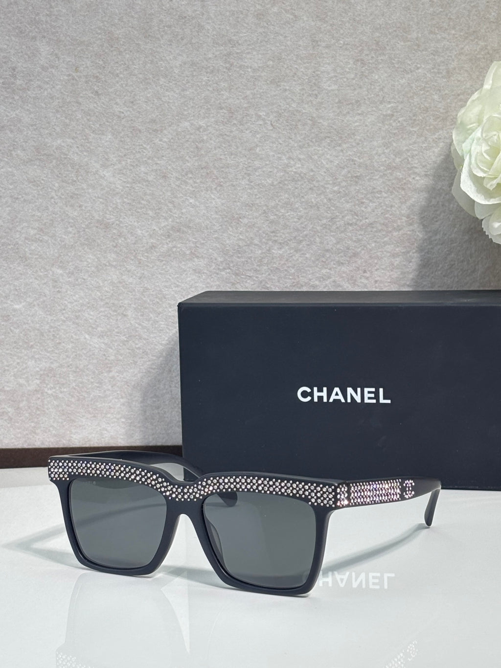 Chanel dark-lens sunglasses with black frame and silver rhinestone front band