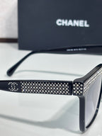 Chanel sunglasses with black frame and silver rhinestone pattern on front bar