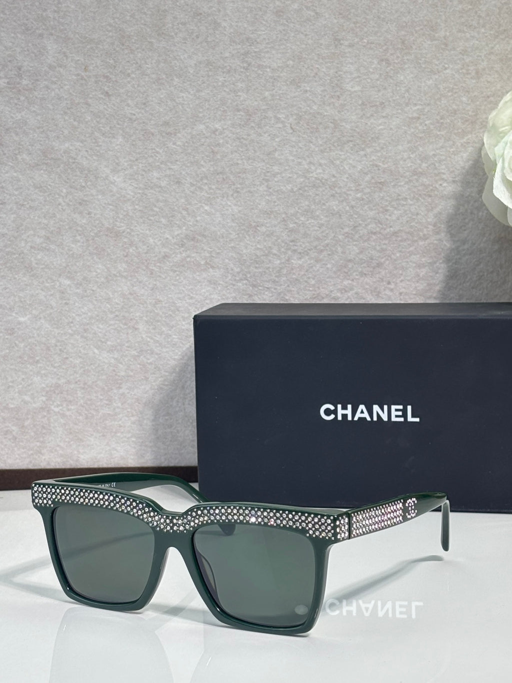Chanel green-lens sunglasses with dark green frame and silver rhinestone top