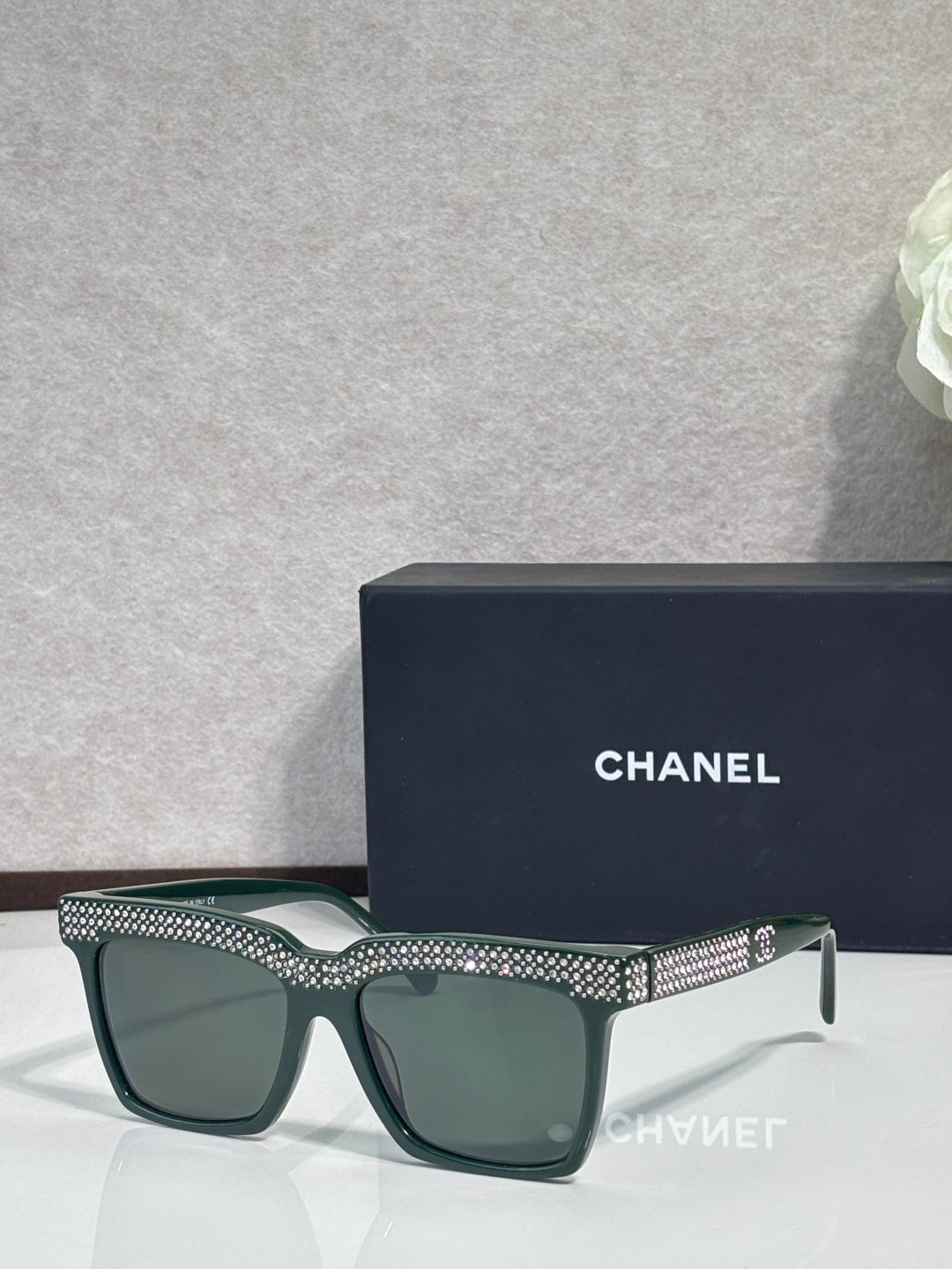 Chanel green-lens sunglasses with dark green frame and silver rhinestone top