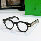 Black acetate eyeglasses with round frames and textured gold detail on temples