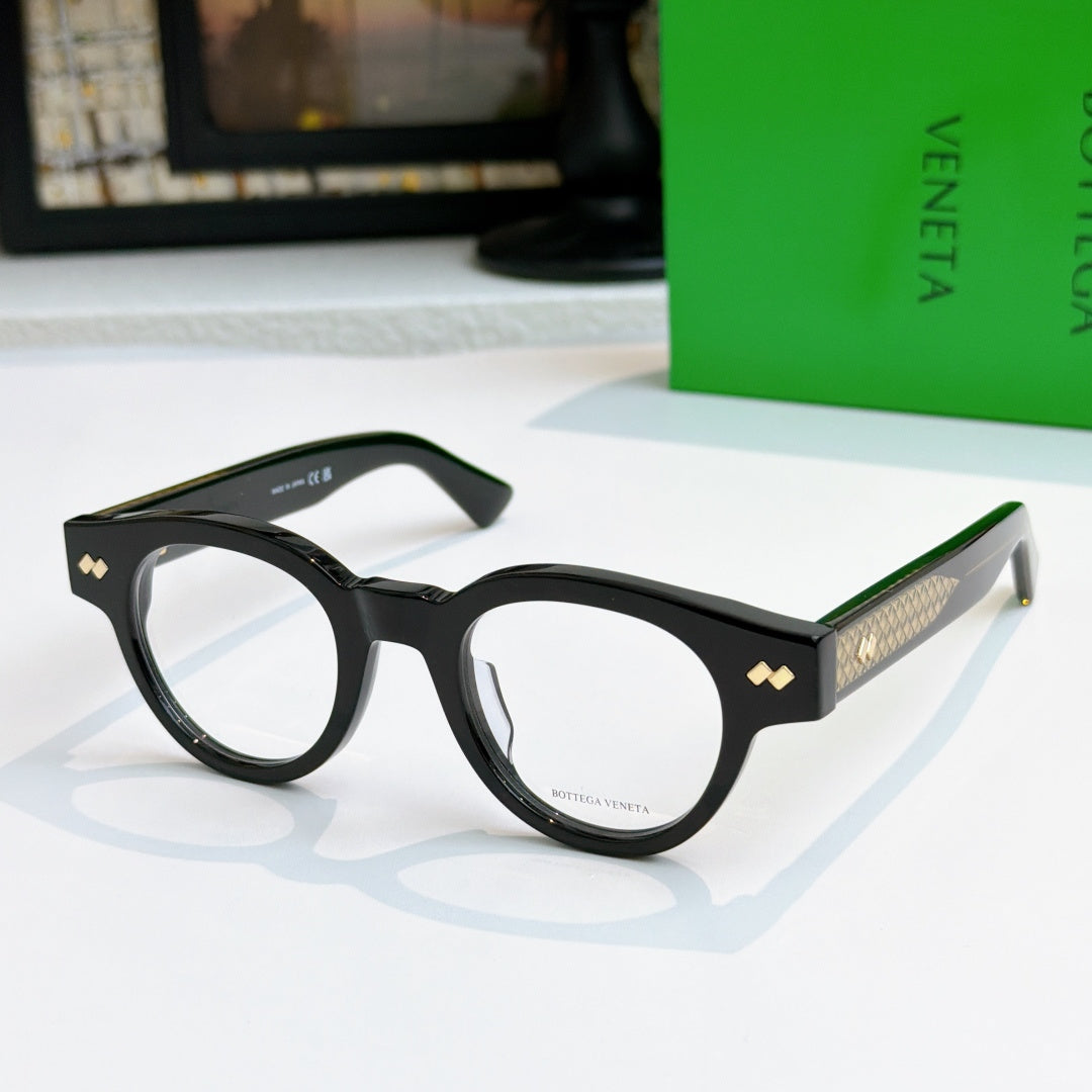 Black acetate eyeglasses with round frames and textured gold detail on temples