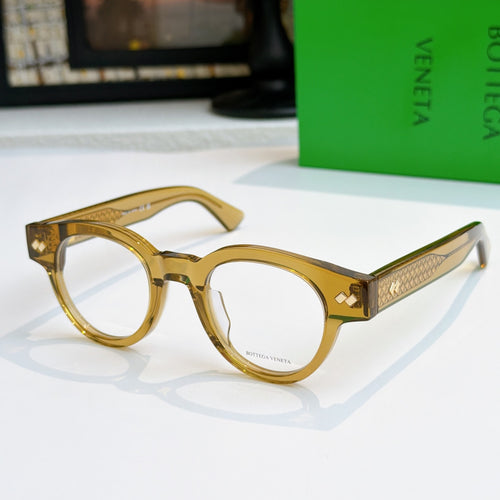 Gold-tone acetate eyeglasses with round frames and engraved pattern on temples