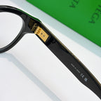 Black acetate eyeglasses close-up of gold logo plate on temple