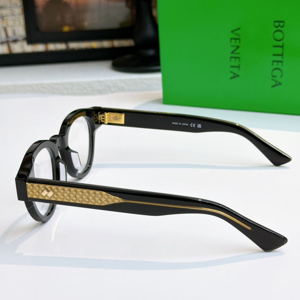 Black acetate eyeglasses side view with gold textured temple and clear lenses