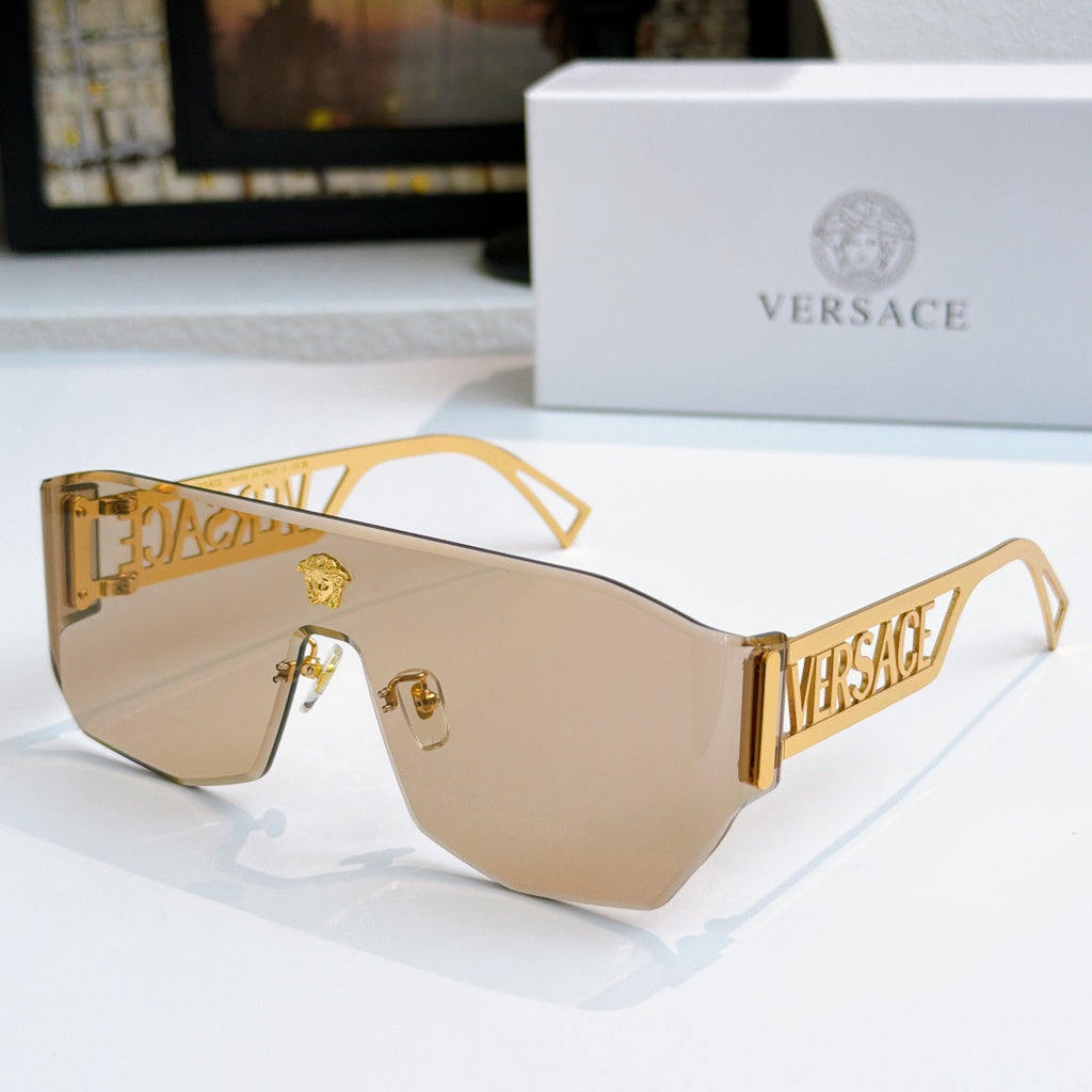 Gold sunglasses with amber mirrored lenses and Versace logo arms