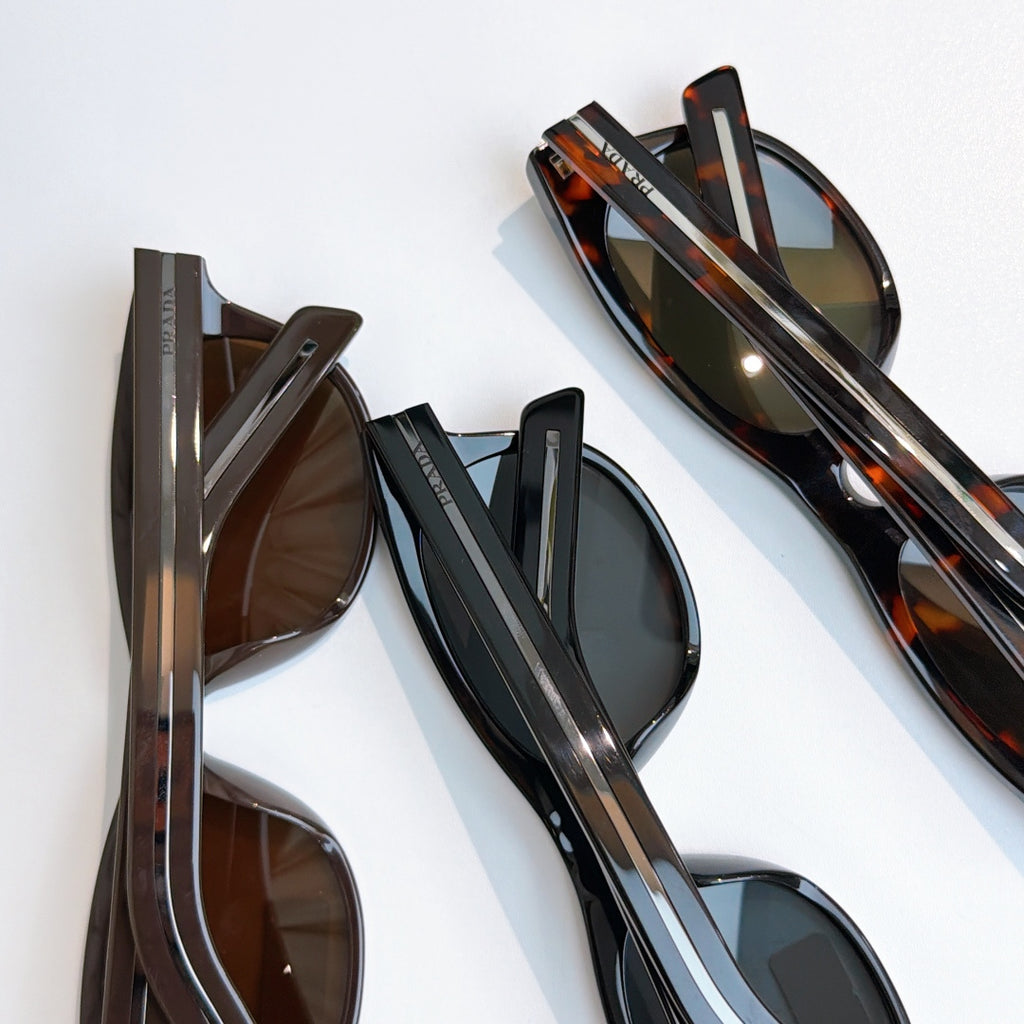 Prada sunglasses laid out with mixed frames and tinted lenses