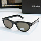 Prada sunglasses side view with black frames and tinted lenses, logo on temple