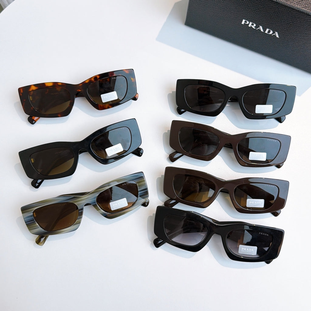 Prada glasses assortment with multiple frame colors and dark lenses, laid out