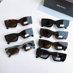 Prada glasses assortment with multiple frame colors and dark lenses, laid out