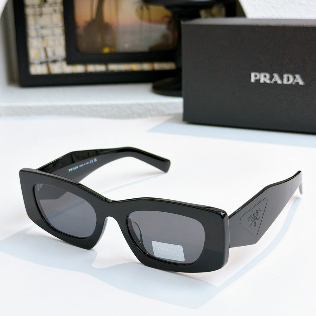 Prada black cat-eye glasses with dark tinted lenses and curved arms