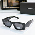 Prada black cat-eye glasses with dark tinted lenses and curved arms