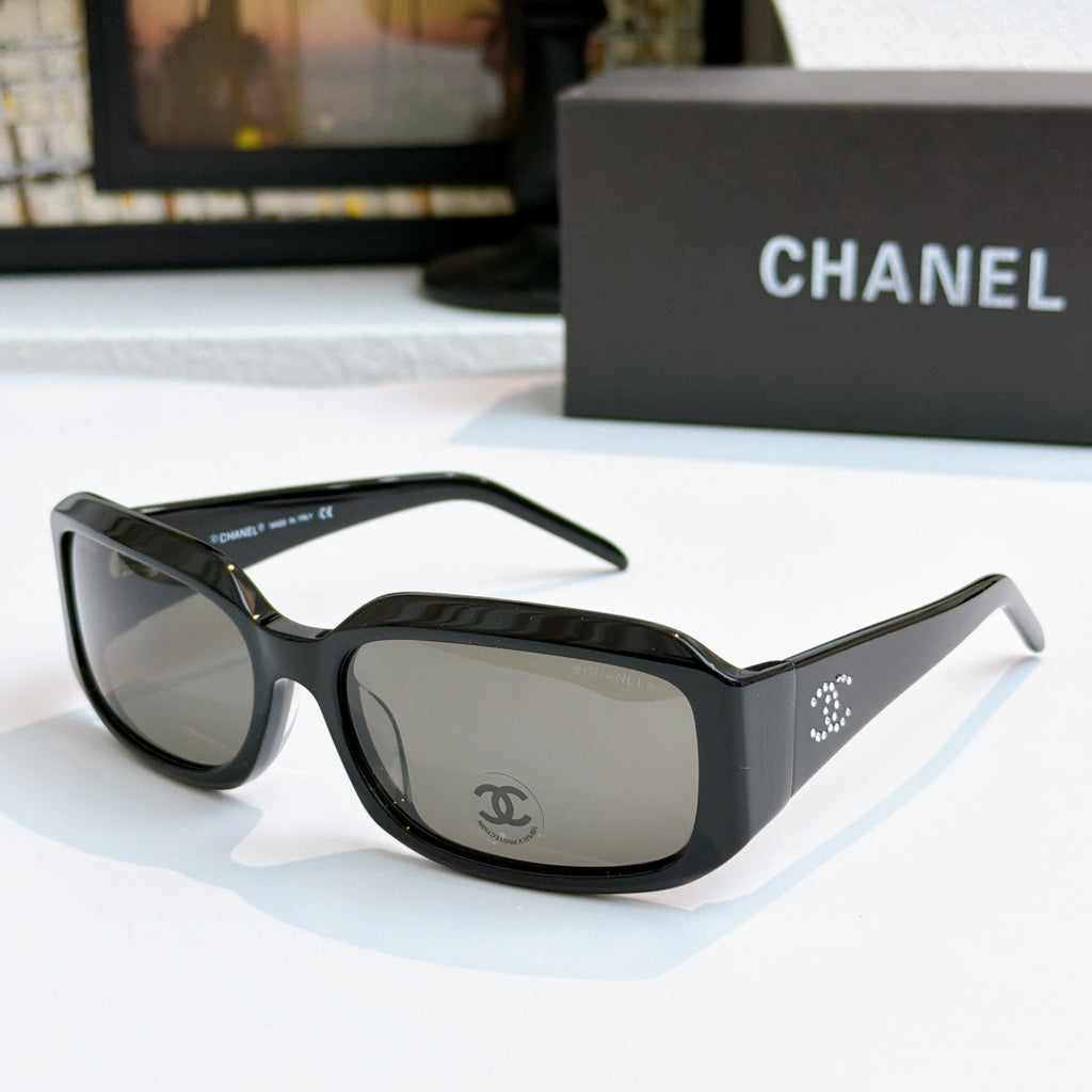 Black cat-eye glasses with clear smoke tinted lenses and side logo detail