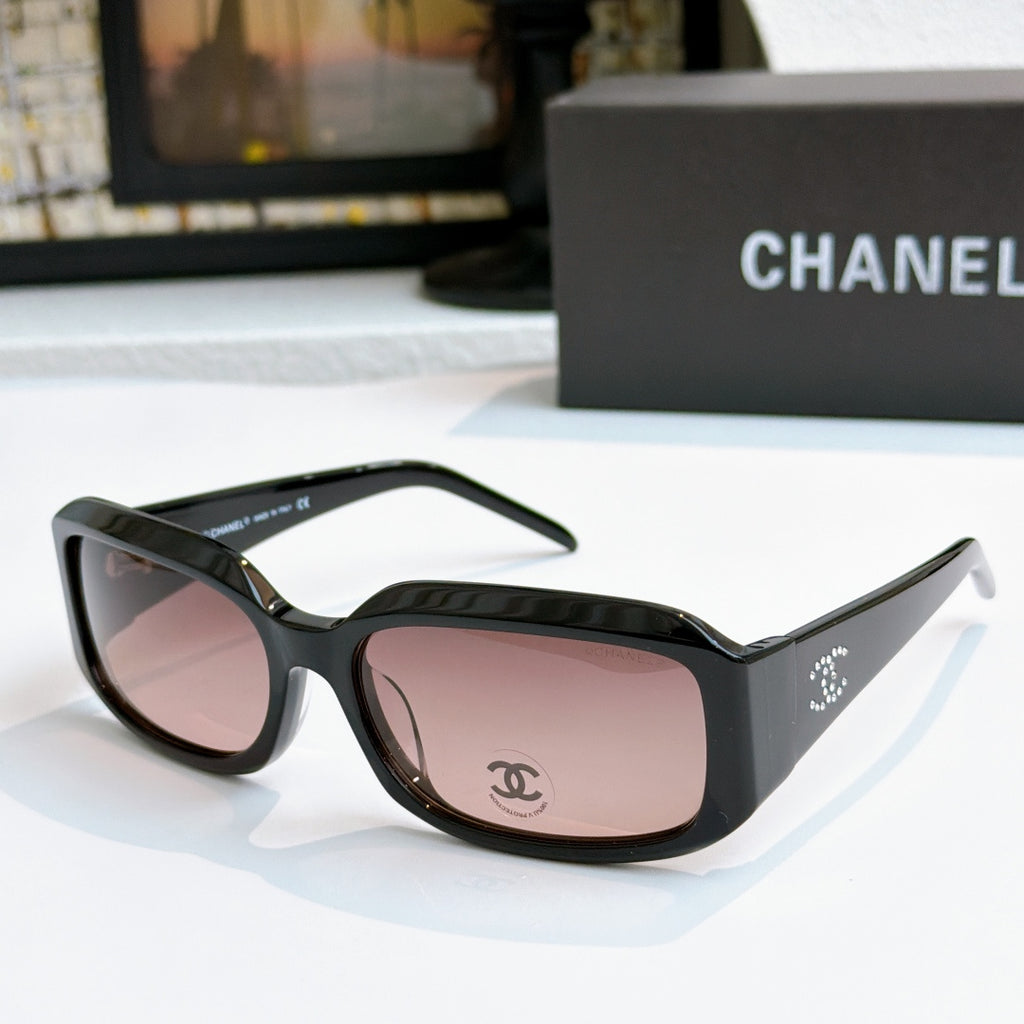 Black cat-eye glasses with rose-pink tinted lenses and side logo detail
