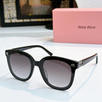 MiuMiu black cat-eye sunglasses with dark lenses and gold-tone logo accents