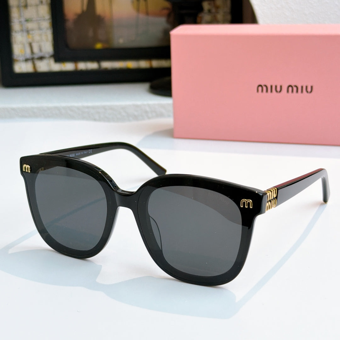 MiuMiu black cat-eye sunglasses with tinted lenses and gold-tone logo plaque